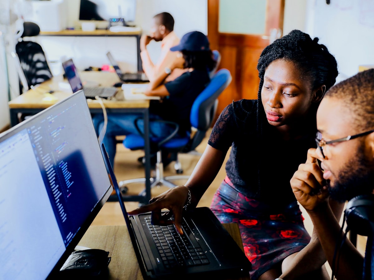 Two colleagues reviewing an automated workflow on screen
