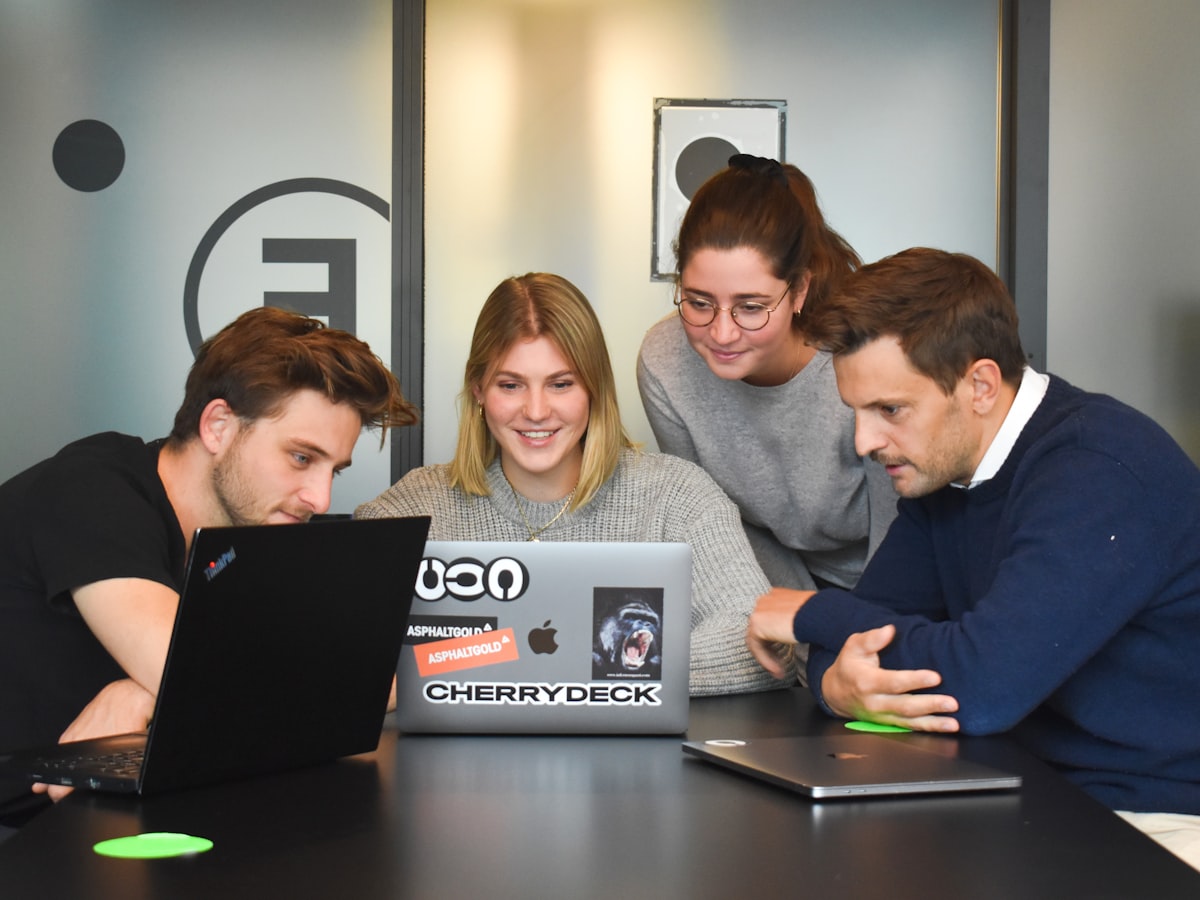 Colleagues working through a plan around a laptop